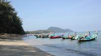 Rawai Beach, long-tail boats and speed boats along the beach.